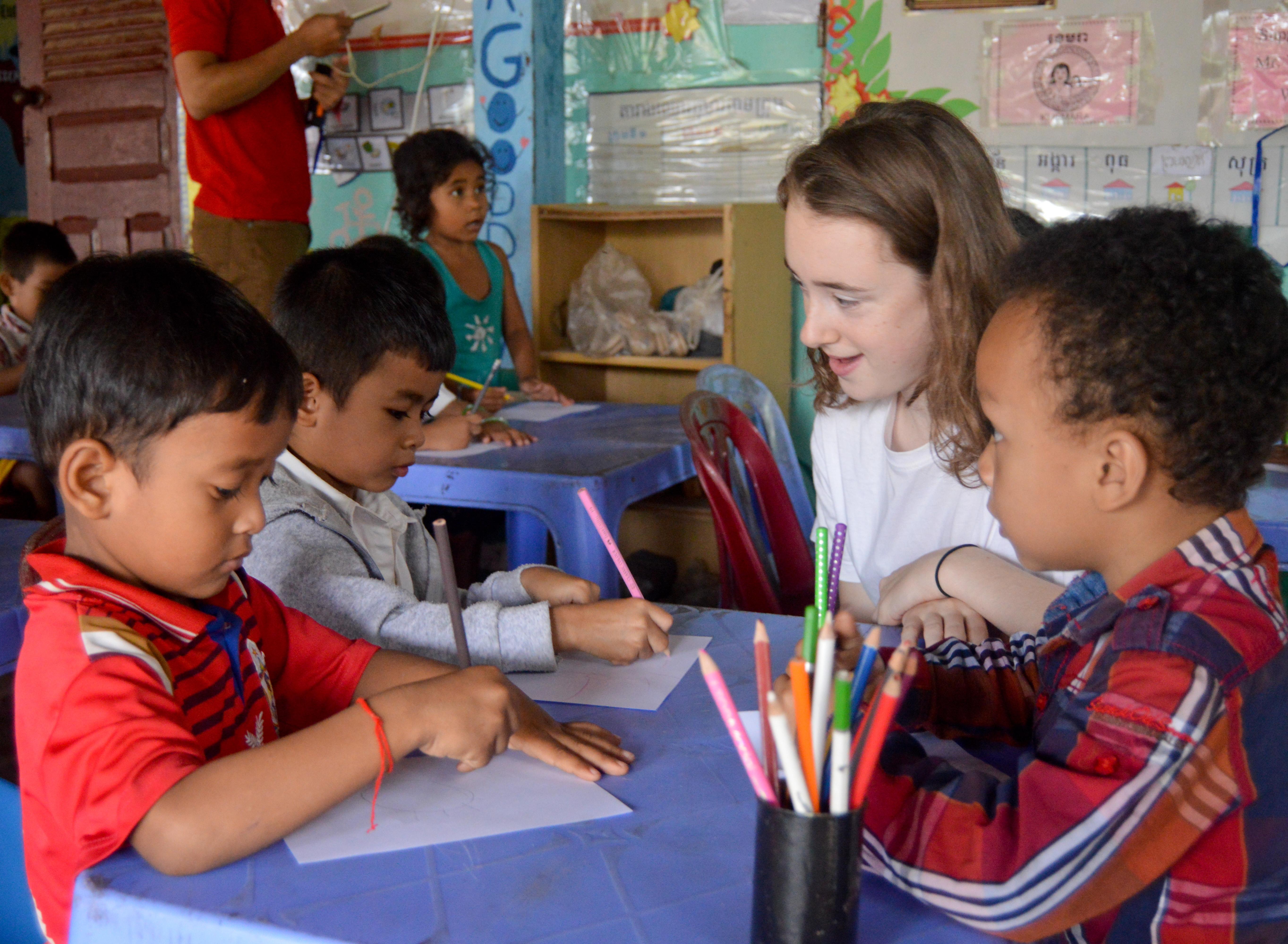 A Childcare volunteer works with children at a day care centre rather than volunteering in orphanages abroad. A Projects Abroad volunteer assists at a community-based care placement rather than orphanage volunteer work.